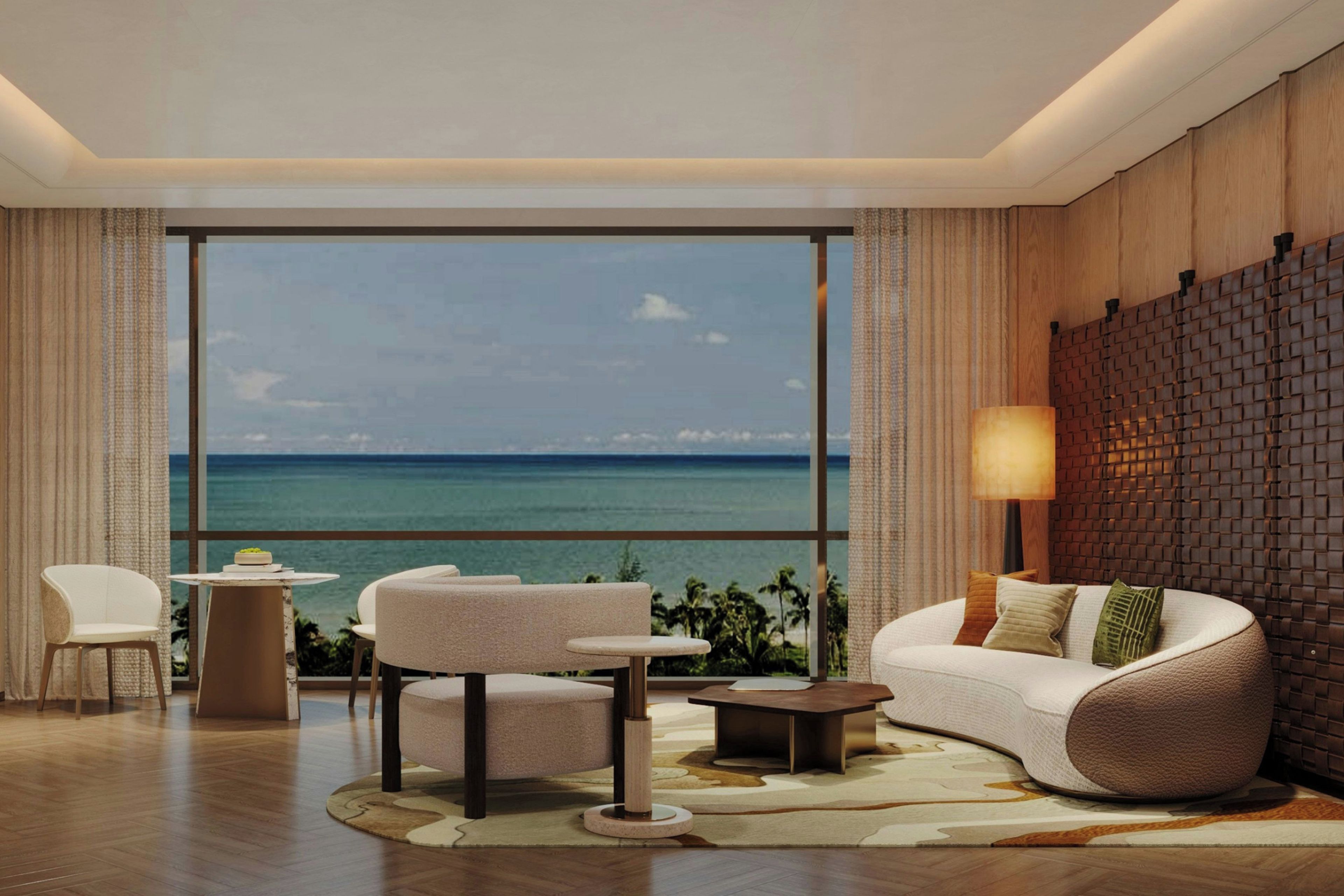 Sala de estar moderna com uma janela ampla com vista para uma praia, mobiliada com sofá, cadeiras e uma mesa pequena.