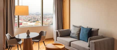 A modern living room with a sofa, a round table, and chairs.