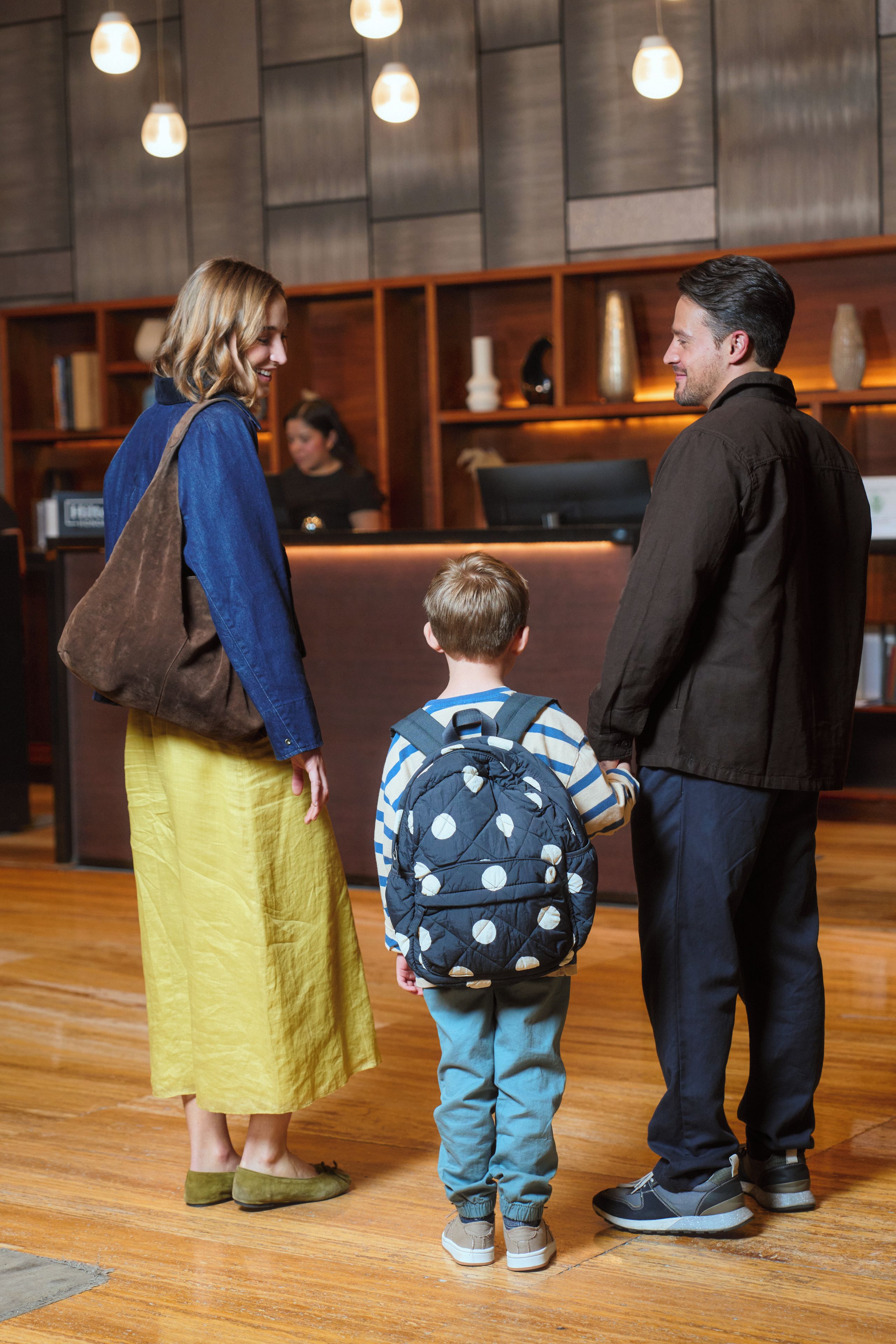 A reception area with wooden paneling, a reception desk, and a bookshelf in the background.