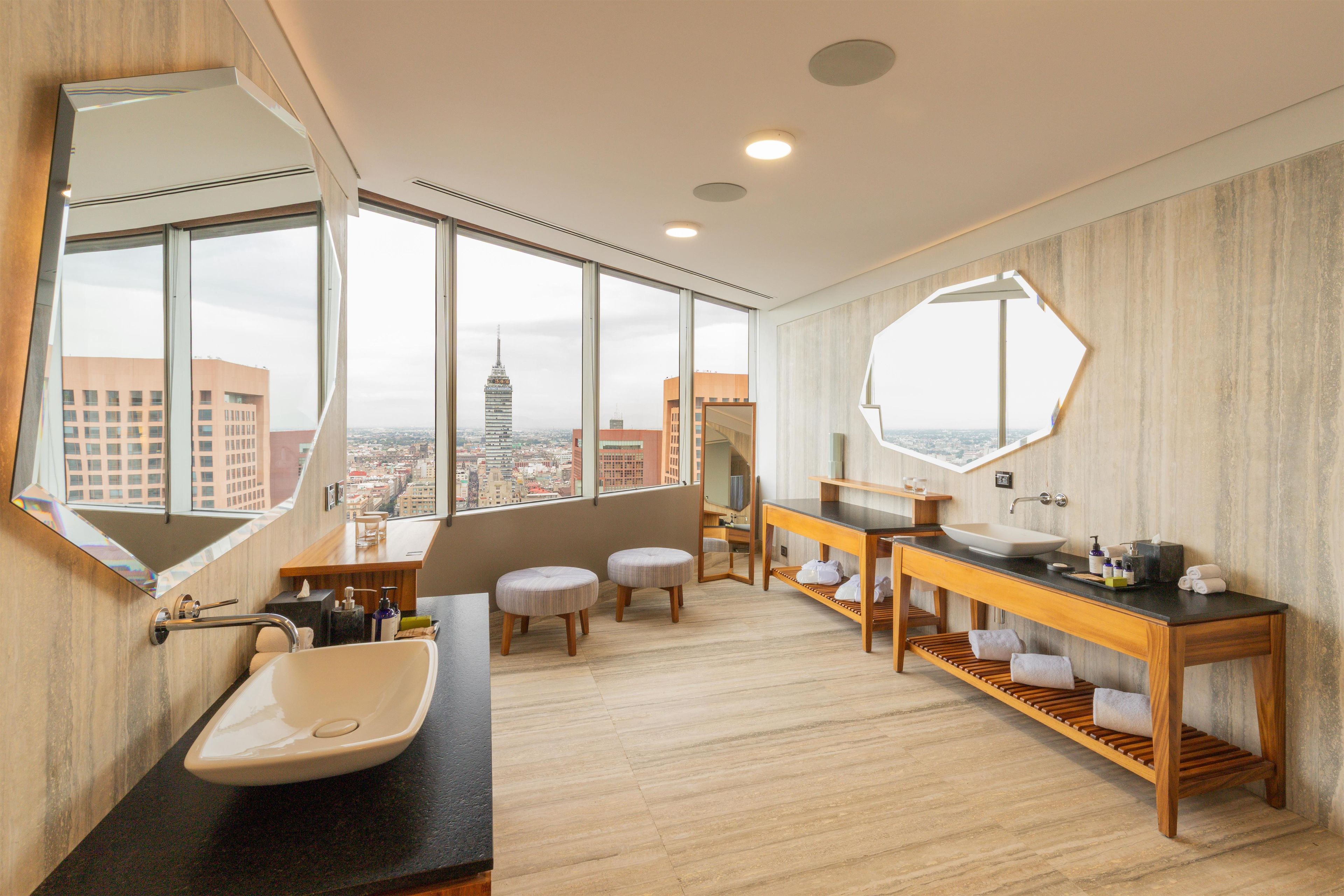 Ein modernes Badezimmer mit großem Fenster, Waschbecken und Spiegel.