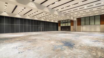 Un vaste espace intérieur doté d’un haut plafond, d’un éclairage encastré et d’un grand mur orné d’un motif en réseau.