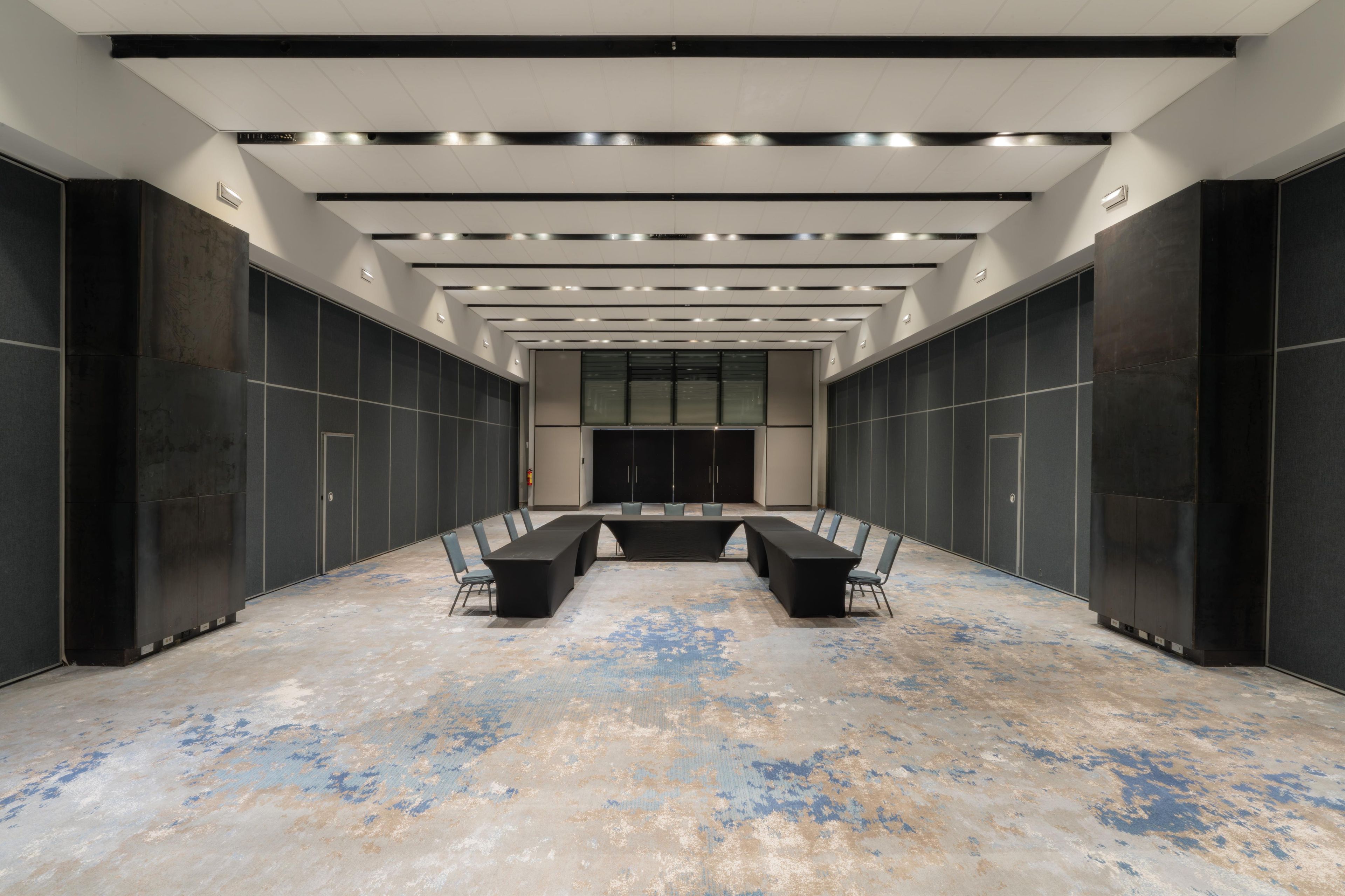 A conference room with a long table, chairs, and a modern ceiling design.