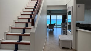 A staircase with white and blue steps leading to a balcony with a view of the ocean. - Sapphire Beach Club Resort (Lowlands)