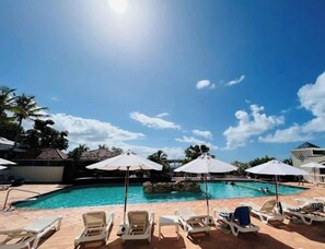 Piscine extérieure, parasols de plage, chaises longues
