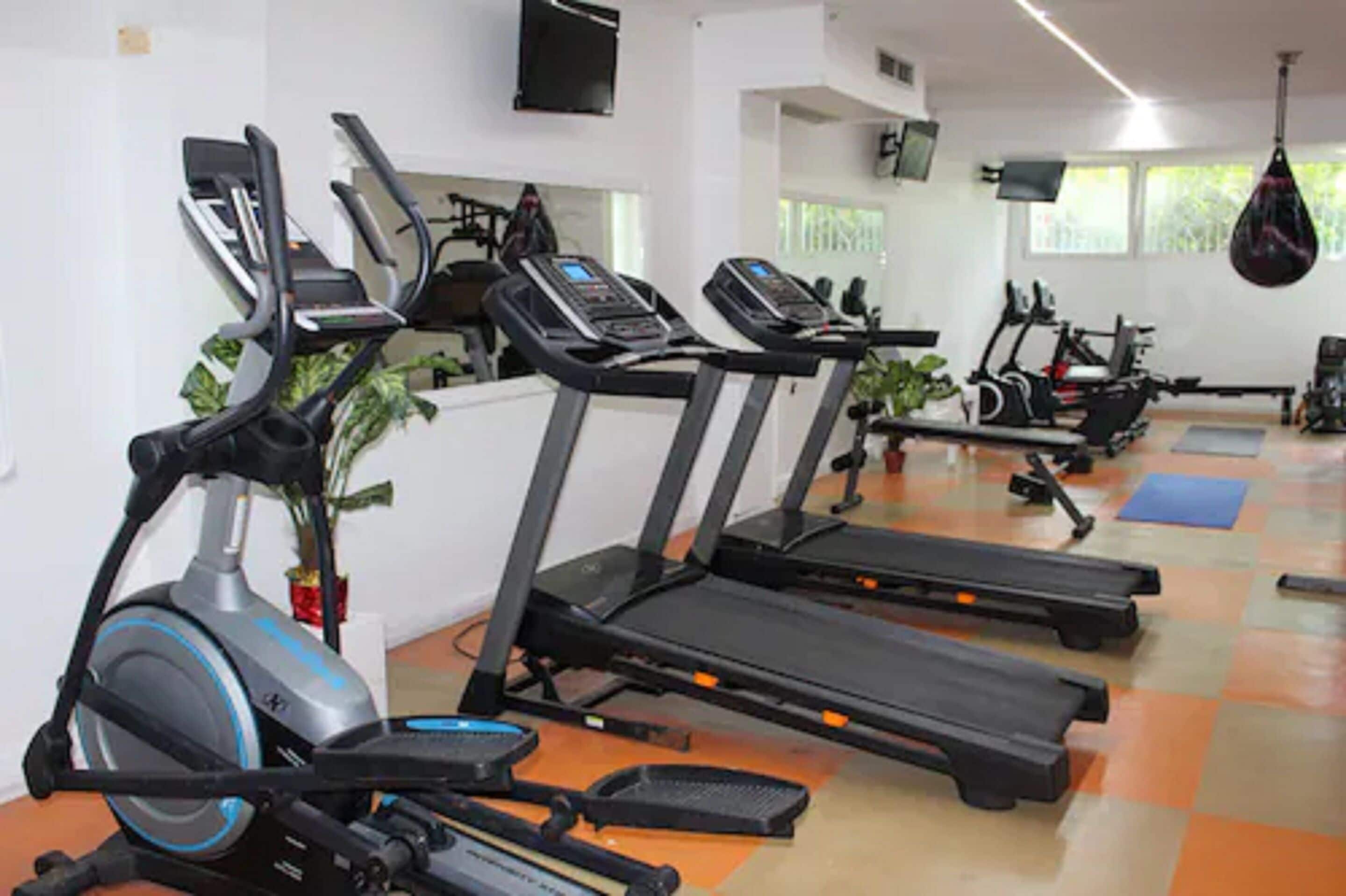 A gym with treadmills, stationary bikes, and exercise equipment.
