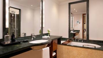 A modern bathroom with two sinks, a large mirror, and a shower.