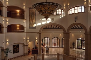A spacious interior with multiple arches, a grand chandelier, and a view of the outside through large windows. - The St. Regis Mardavall Mallorca Resort (Calvia)