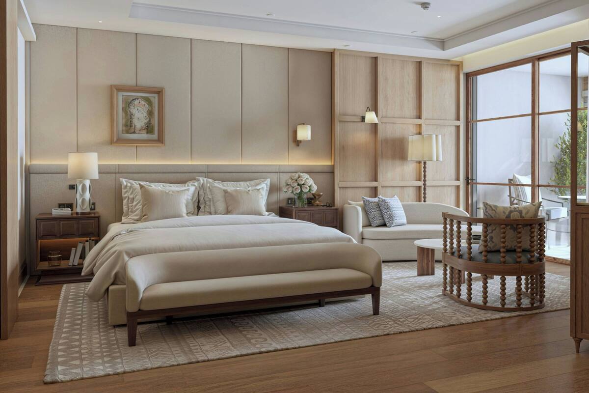 A spacious bedroom with a large bed, bedside tables, a chair, and a wooden cabinet.