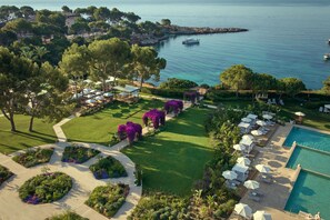 A resort with a pool, sun loungers, and a view of the sea. - The St. Regis Mardavall Mallorca Resort (Calvia)