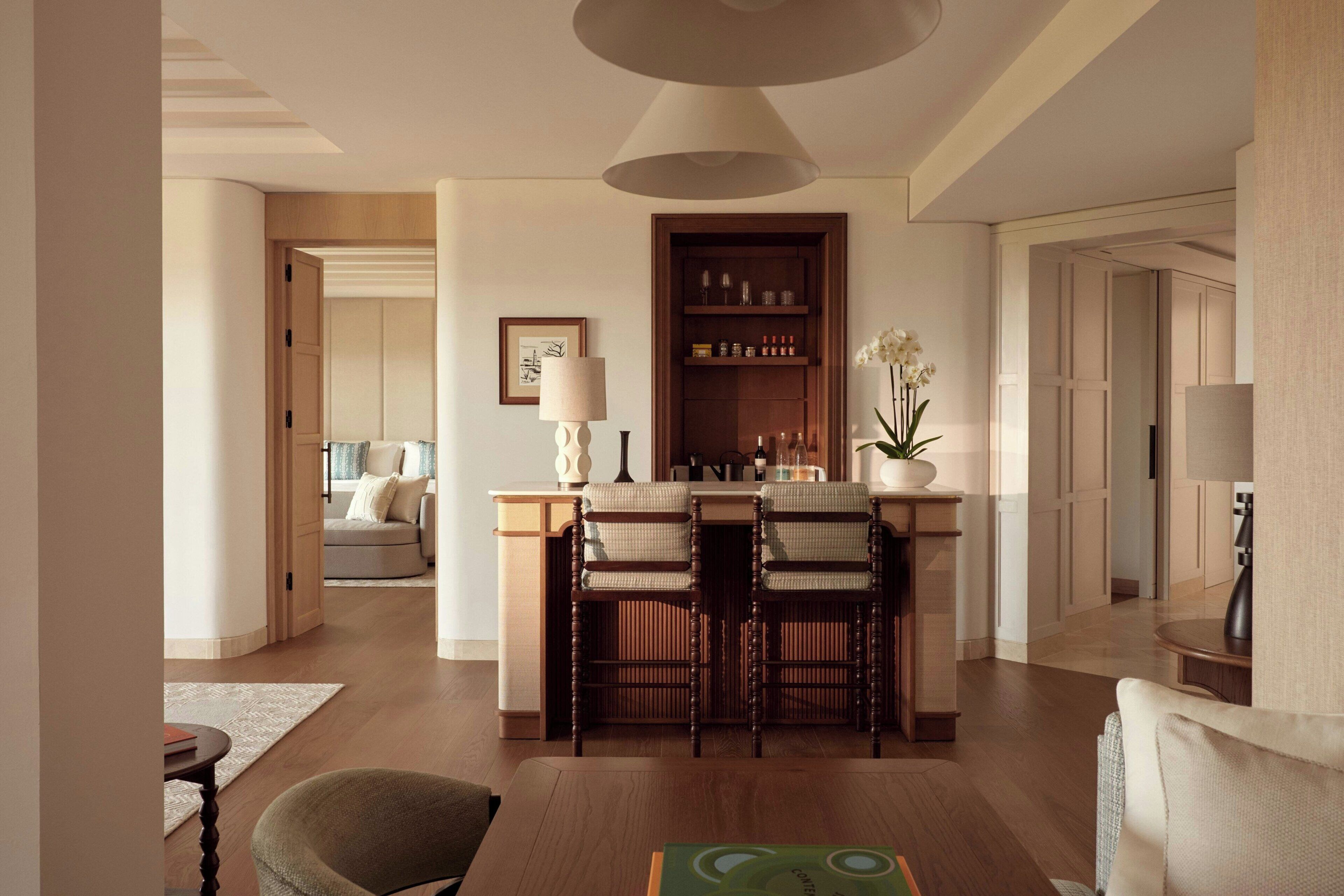 A modern living room with a dining area, featuring a wooden dining table with chairs, a sofa, and a coffee table.
