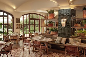 A spacious dining area with high ceilings, large windows, and a variety of seating options including tables and chairs. - The St. Regis Mardavall Mallorca Resort (Calvia)