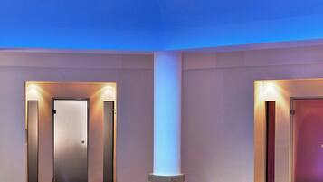 A spacious indoor area with a tiled floor, two doors, and a central circular feature.