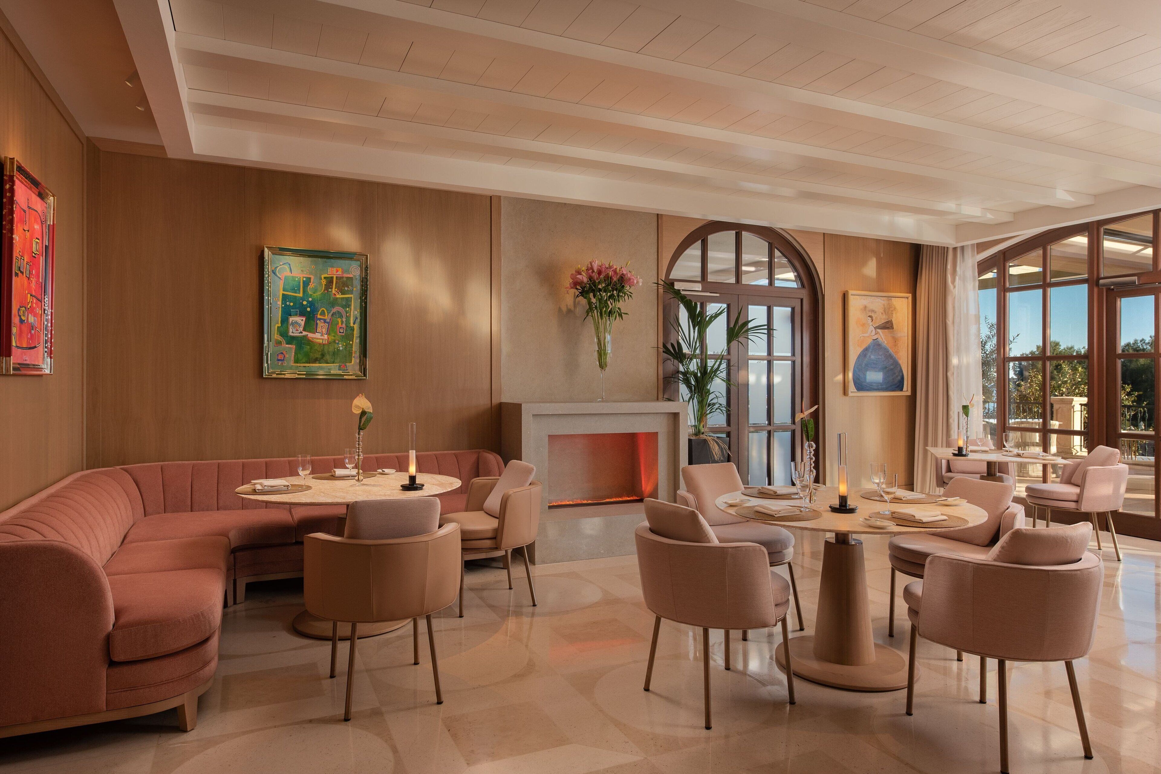 A modern lounge area with a curved sofa, round tables, and comfortable seating.