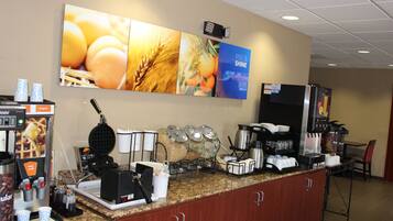 A breakfast bar with coffee machines, a waffle maker, and food dispensers.