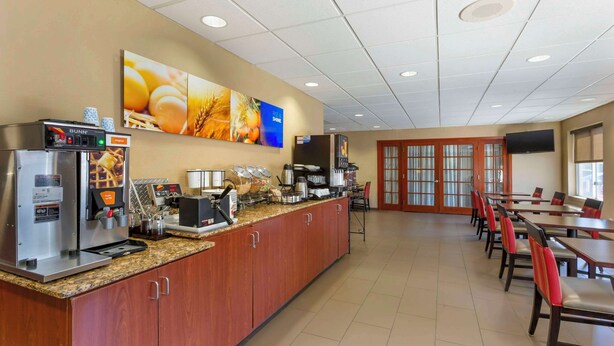A breakfast area with a coffee machine, a microwave, and a buffet counter. There are tables and chairs arranged for dining. - Comfort Inn Green Valley I-19 (Green Valley)