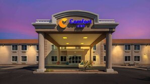 A Comfort Inn hotel entrance with a clear sky in the background.