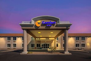 A Comfort Inn hotel entrance with a clear sky in the background.