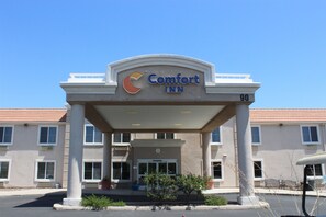 A Comfort Inn hotel entrance with a clear sky above.