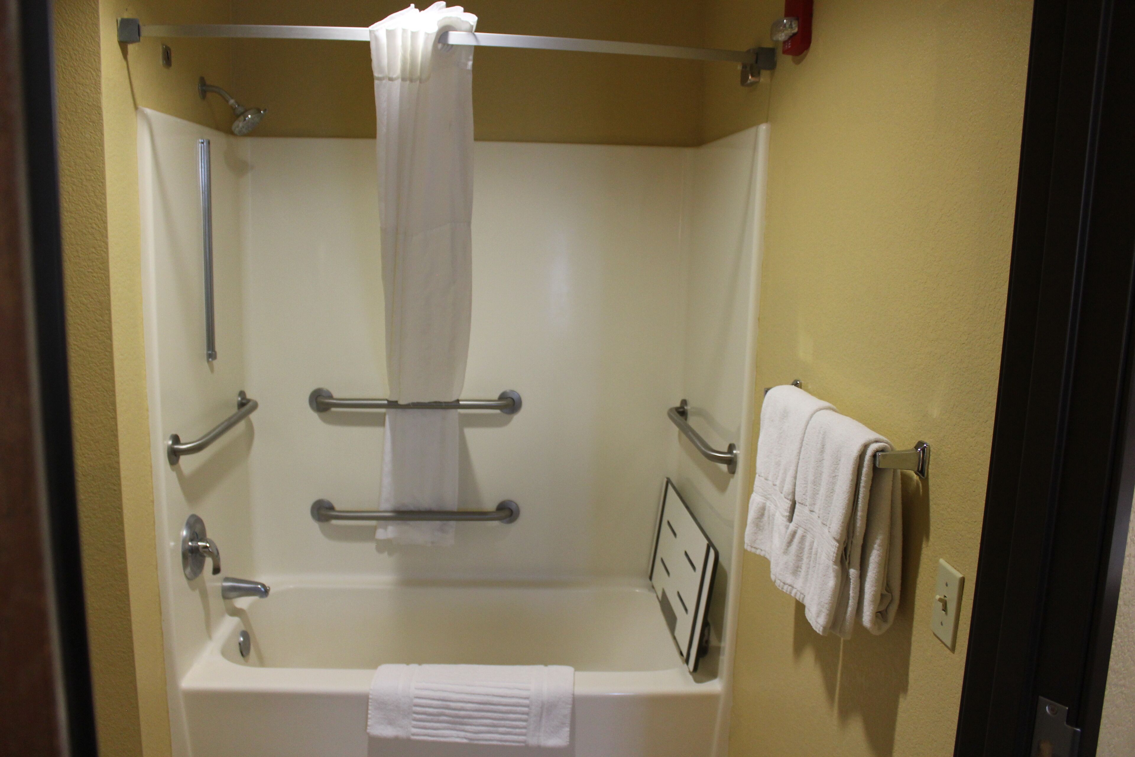 A standard hotel bathroom with a bathtub, a shower, and a toilet.
