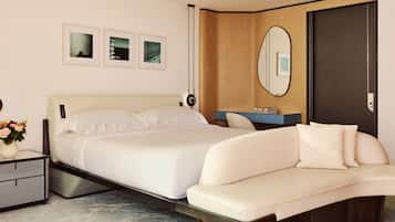 Un dormitorio moderno con una cama grande, una mesita de noche con un jarrón de flores, un banco empotrado, un espejo y cuadros enmarcados en la pared.