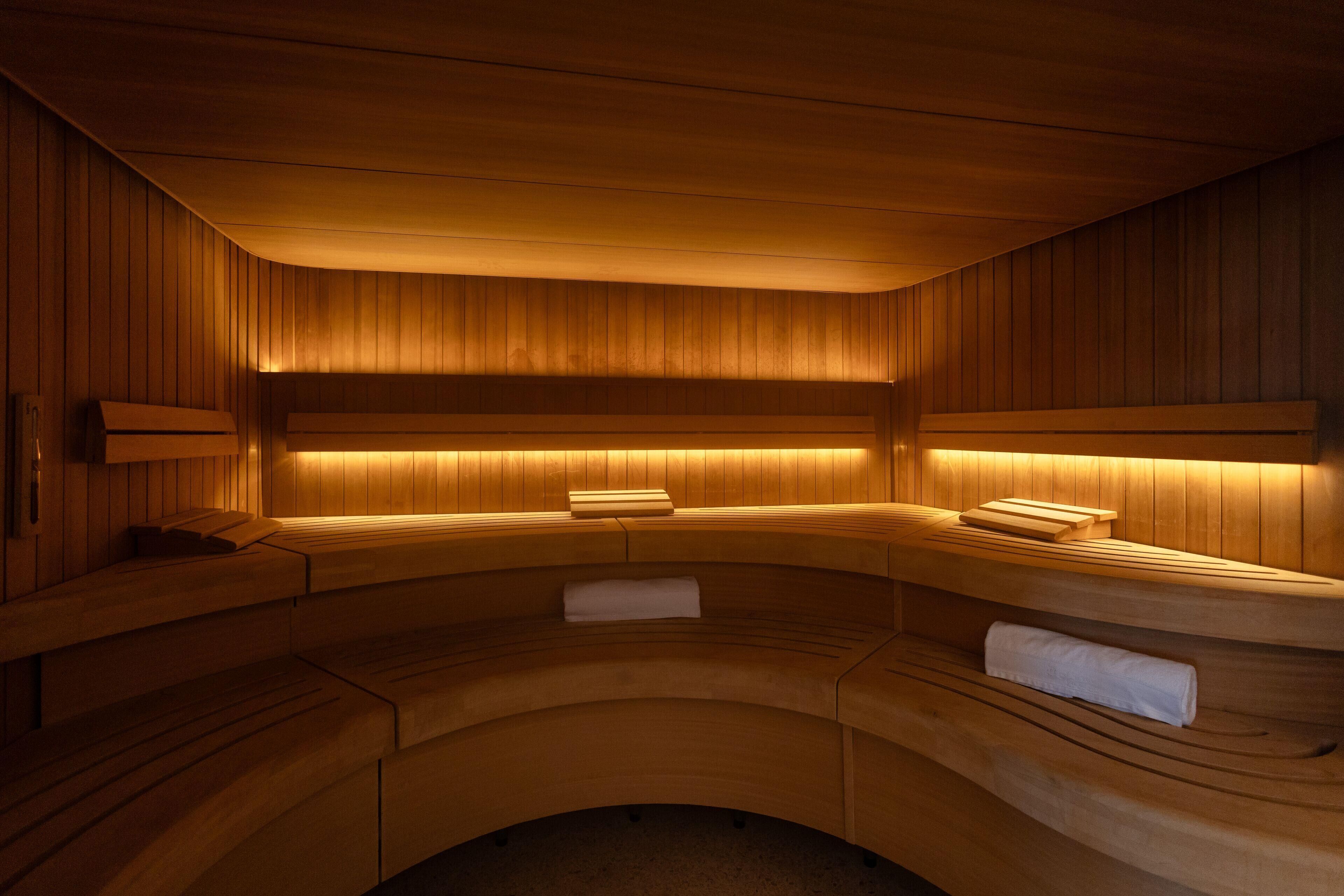 A sauna with wooden benches and benches, a bench with a towel, and a bench with a towel.