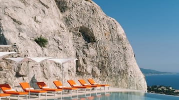 Alberca al aire libre, sombrillas en la alberca y camastros