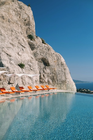 Una piscina al aire libre, sombrillas, sillones reclinables de piscina. The Maybourne Riviera, Maybourne