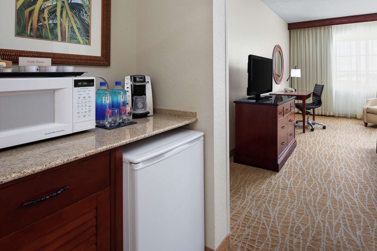 Une chambre d’hôtel équipée d’une kitchenette, d’un lit, d’un bureau et d’une chaise.