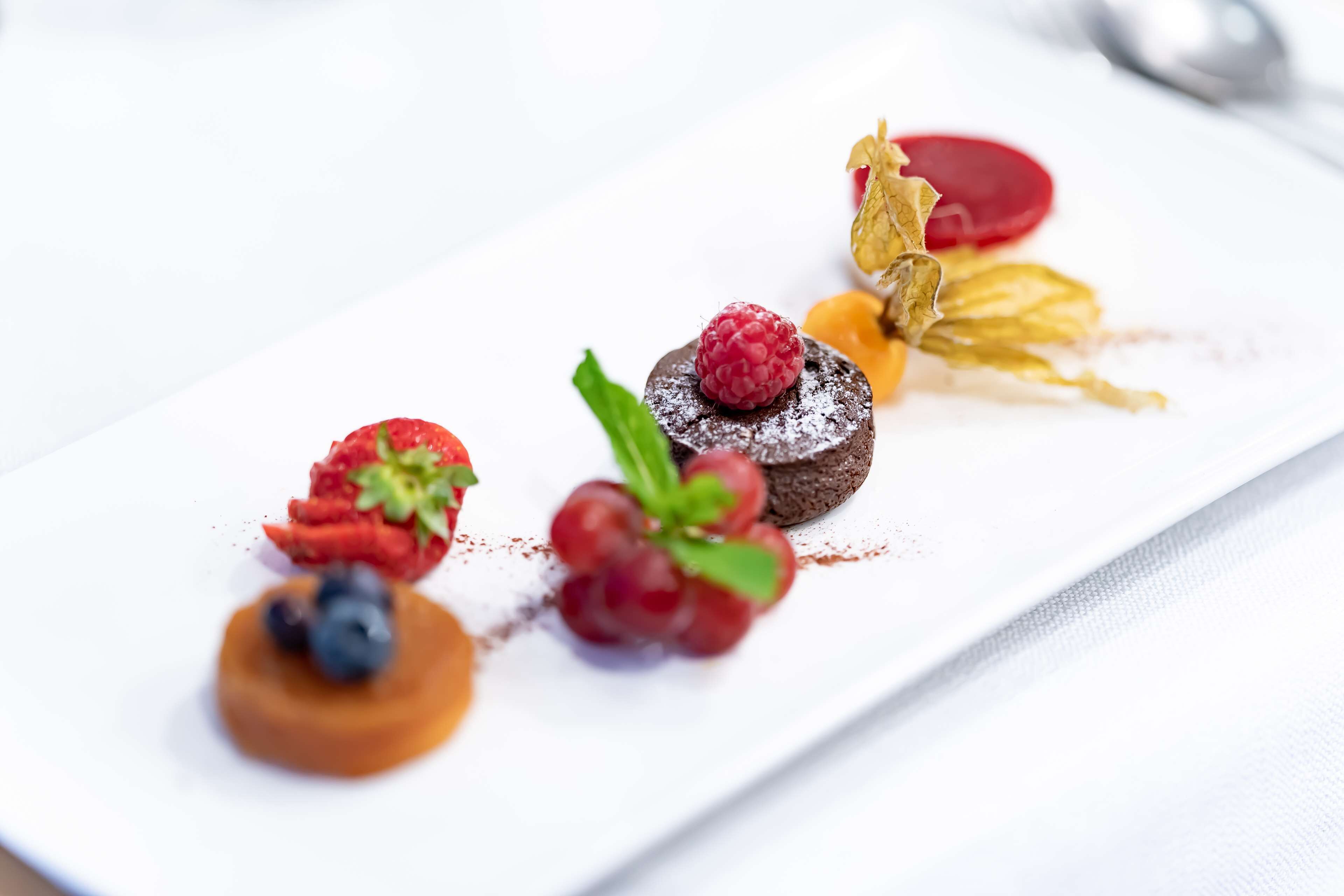 Une assiette de dessert garnie de divers fruits et de morceaux de chocolat.