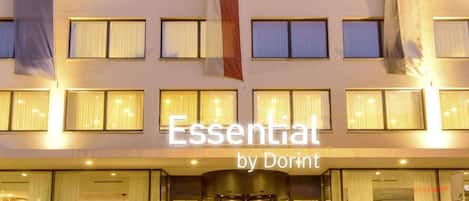 Experience the modern entrance of Essential by Dorint, featuring a symmetrical facade and revolving glass doors.