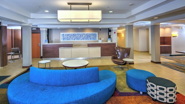 A modern lobby with a reception desk, seating area, and a colorful carpet. - Fairfield Inn & Suites by Marriott Dover (Dover)