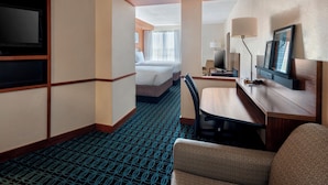 A hotel room with a bed, a desk with a chair, a TV, and a window with curtains. - Fairfield Inn & Suites by Marriott Dover (Dover)