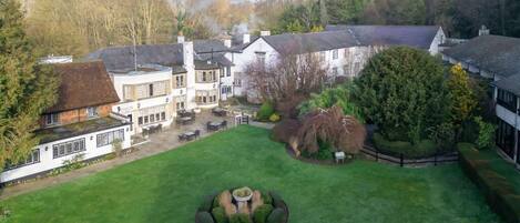 A large estate with multiple buildings, a well-maintained lawn, and a circular garden feature.