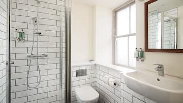 A bathroom with a shower, toilet, and sink.