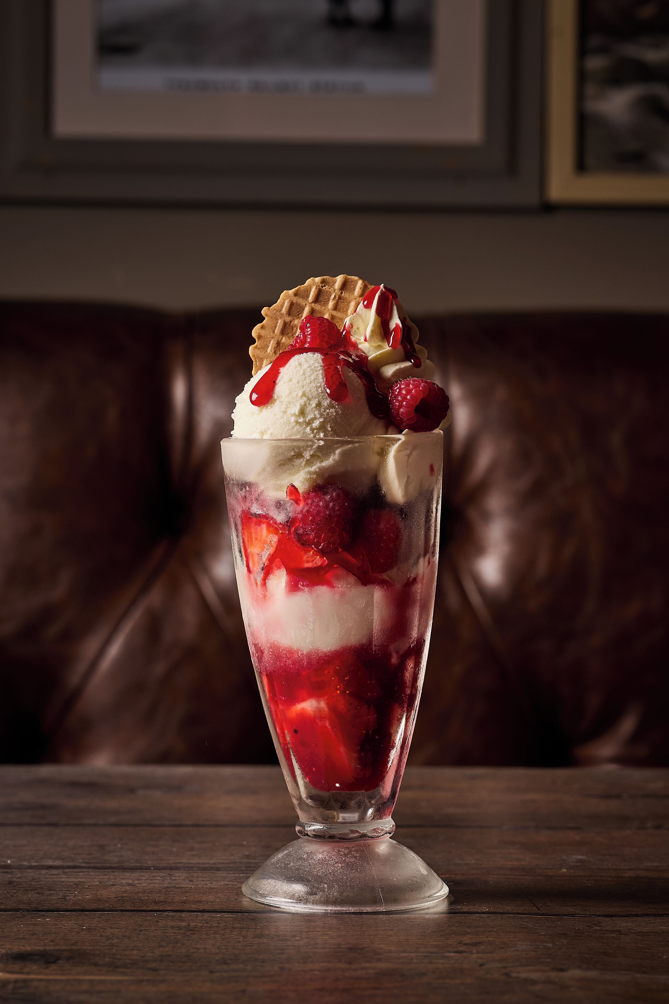 A dessert in a glass on a wooden table.