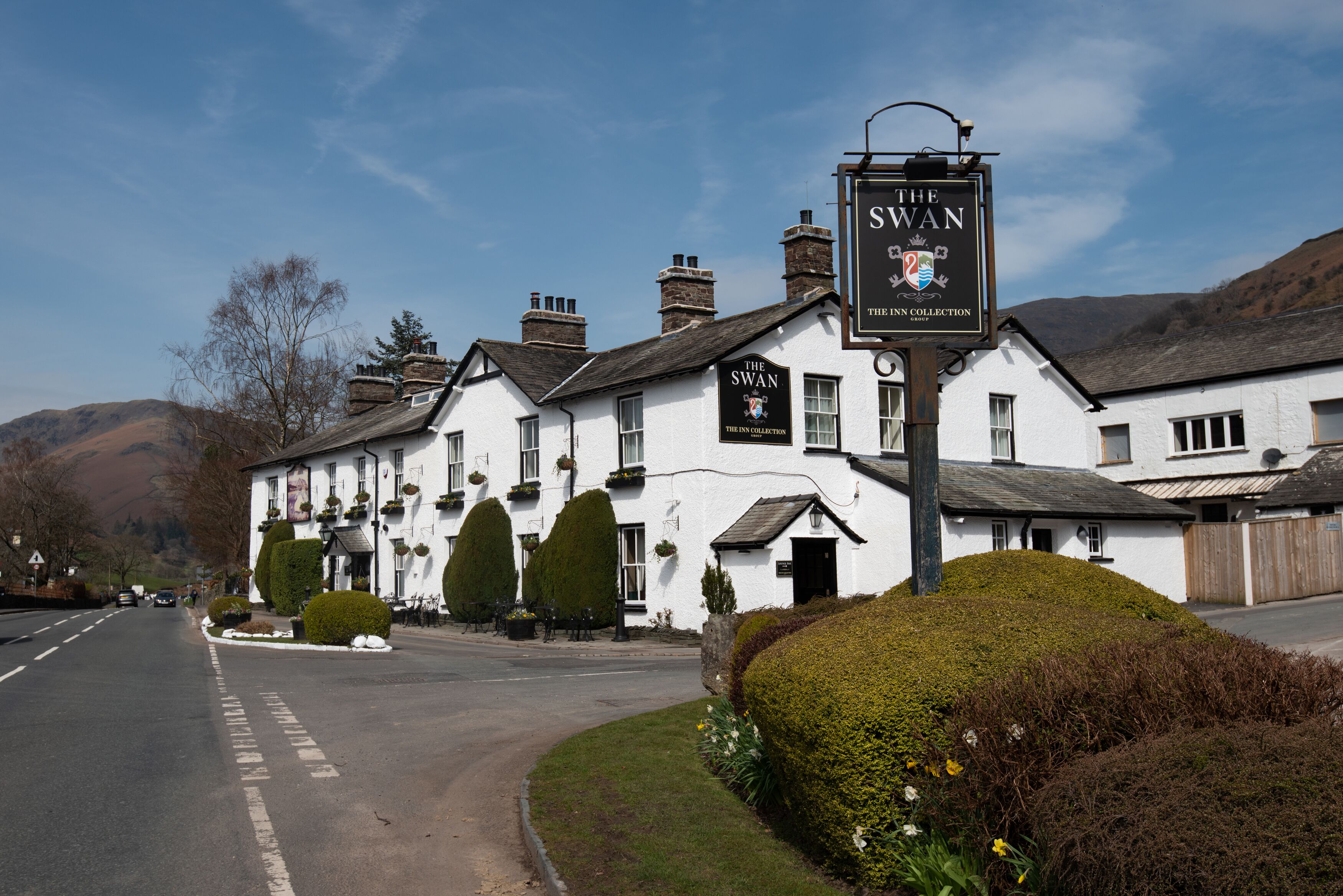 A white building with a sign reading "The Swan" and "The Inn Collection" on its facade.