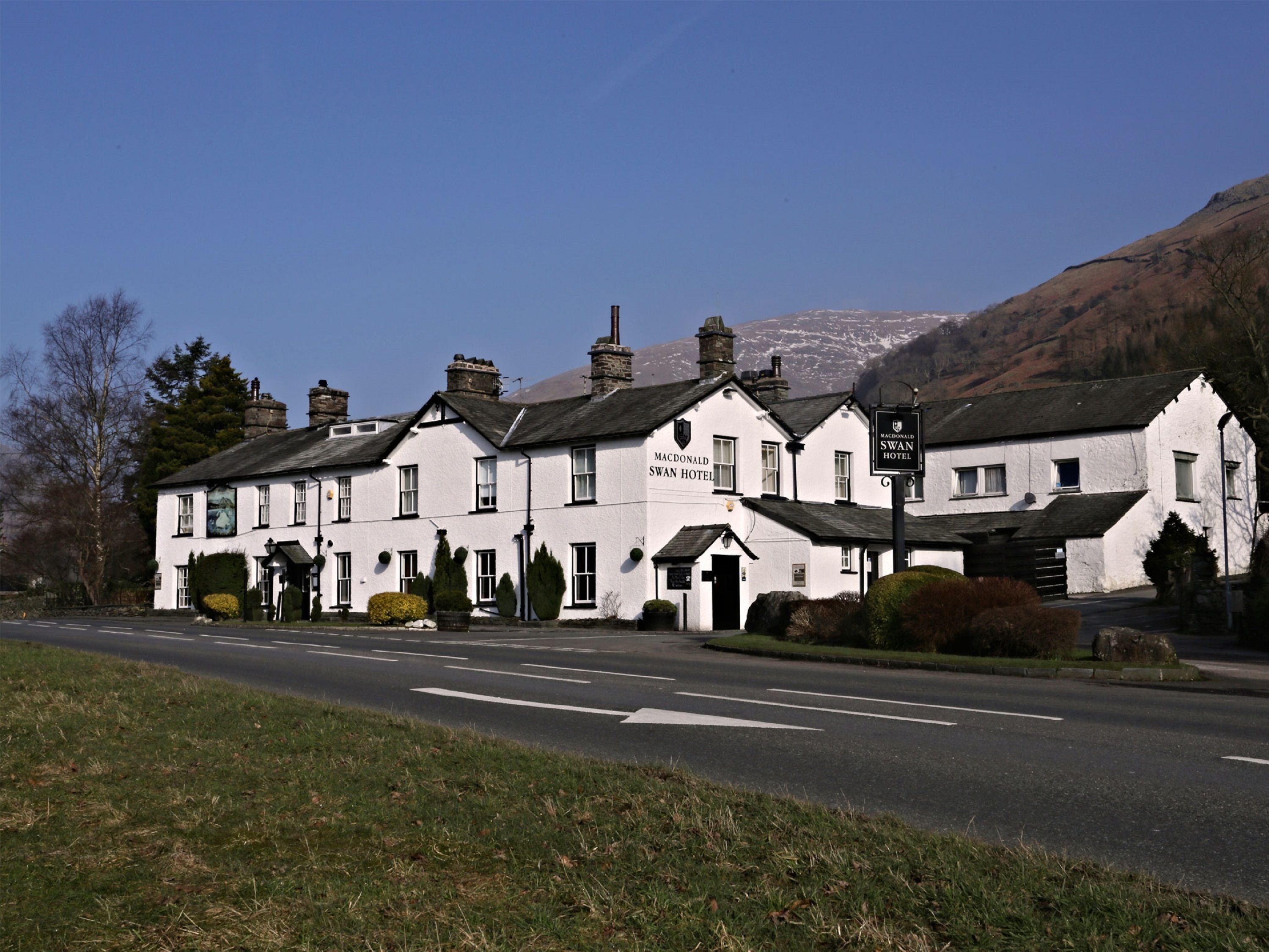 A white building with the sign "Macdonald Swan Hotel" on the front.