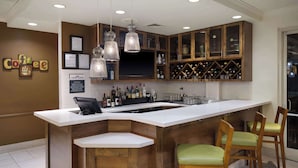 A modern kitchen with a bar area, wooden cabinets, and a wine rack. - Hilton Garden Inn Houston/Bush Intercontinental Airport (Houston)