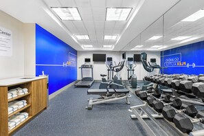 A gym with exercise equipment, a bench, and dumbbells. - Holiday Inn Express Hotel & Suites Charlotte by IHG (Charlotte)