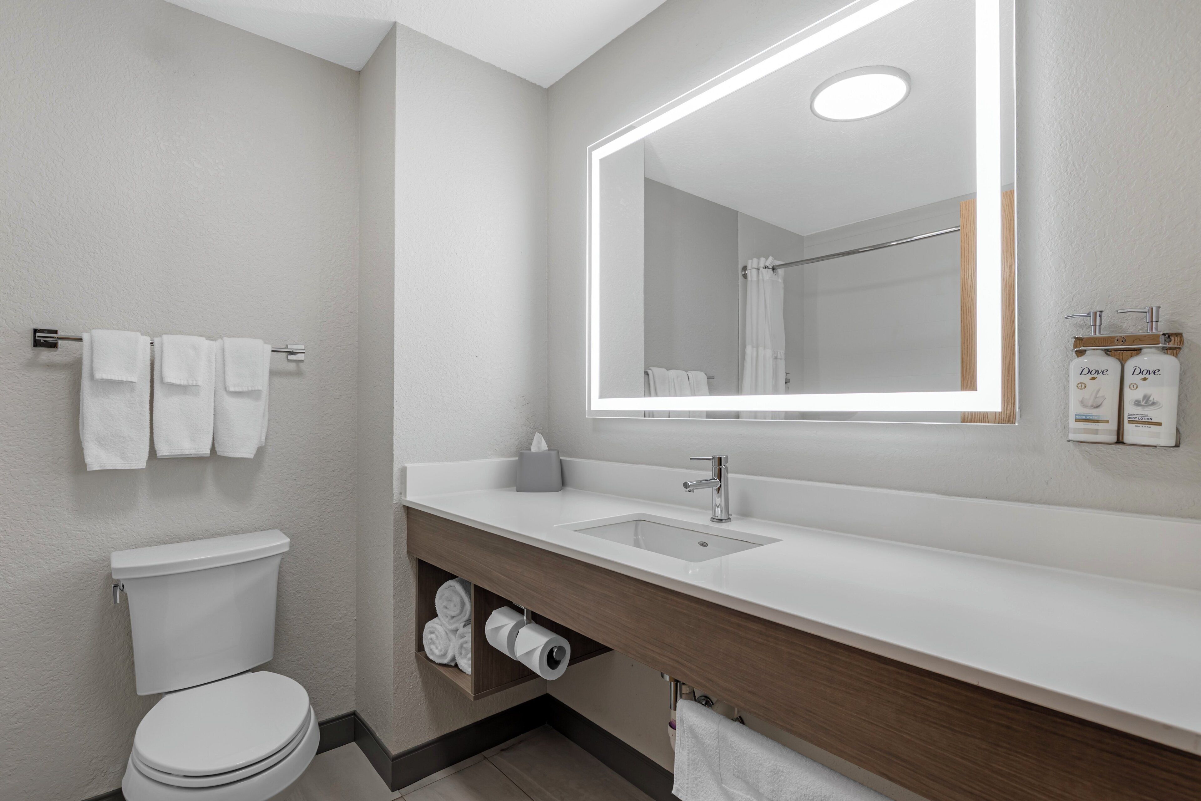 Un bagno moderno con il water, un lavandino e uno specchio.