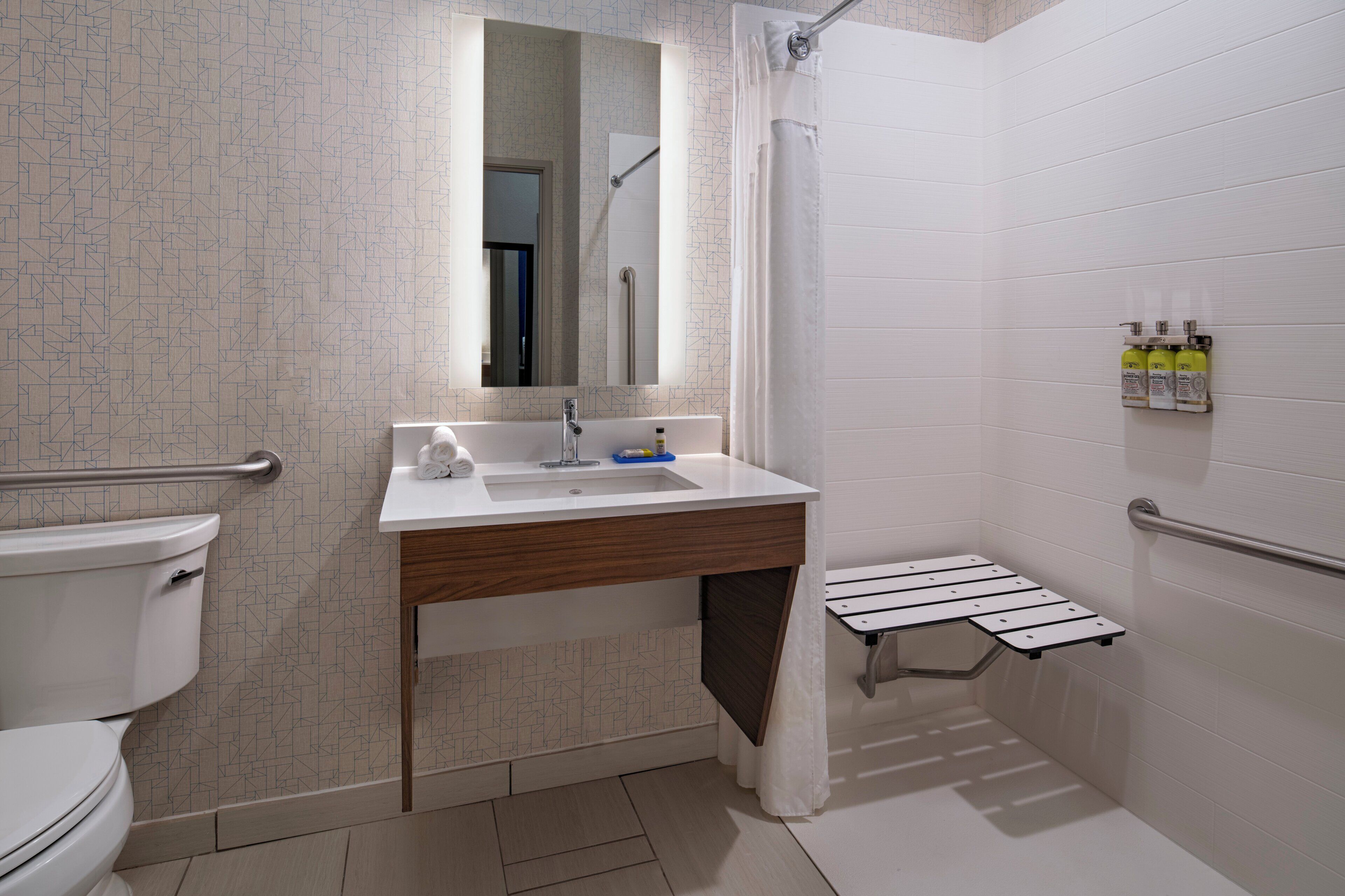 A modern bathroom with a toilet, sink, and shower area.