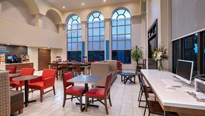 A modern dining area with multiple tables and chairs, a coffee station, and large windows. - Holiday Inn Express Hotel & Suites Cedar Park by IHG (Cedar Park)