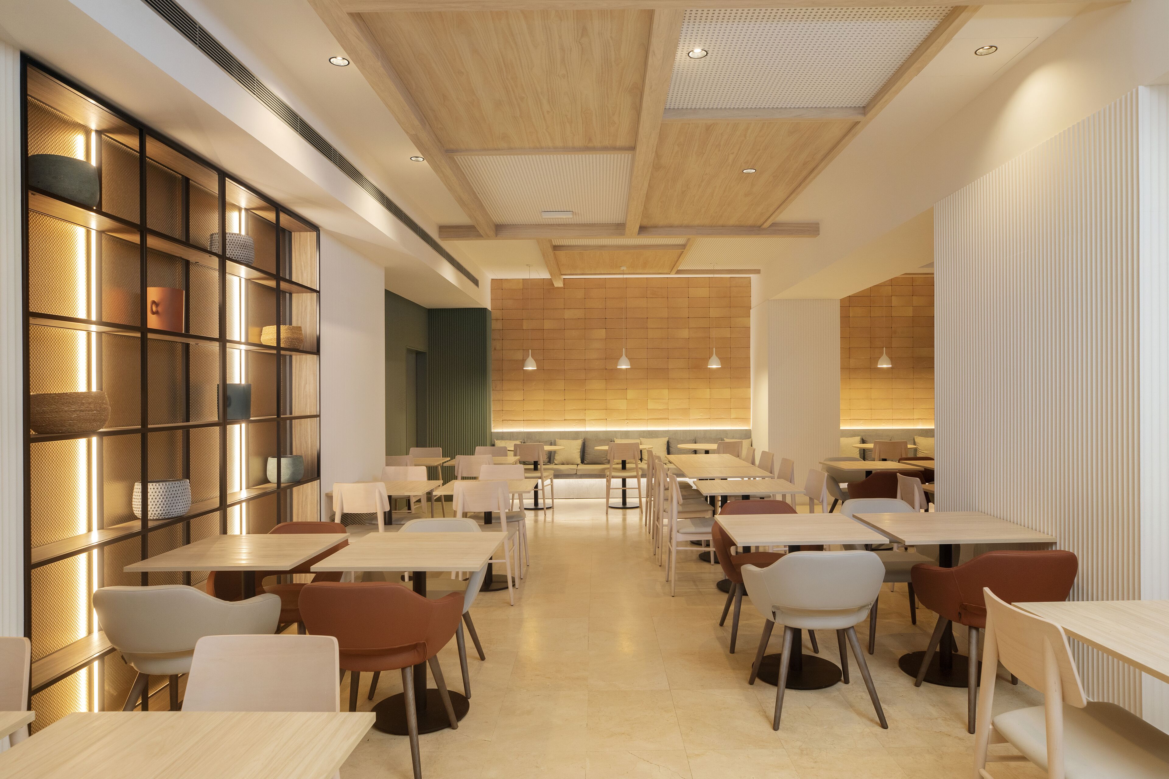 Ein modernes Restaurant mit Holzbalkendecke, weißen Tischen und Stühlen.