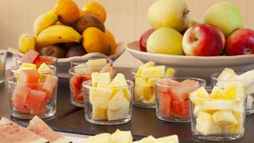 A variety of fruits including apples, bananas, and oranges displayed on a table.