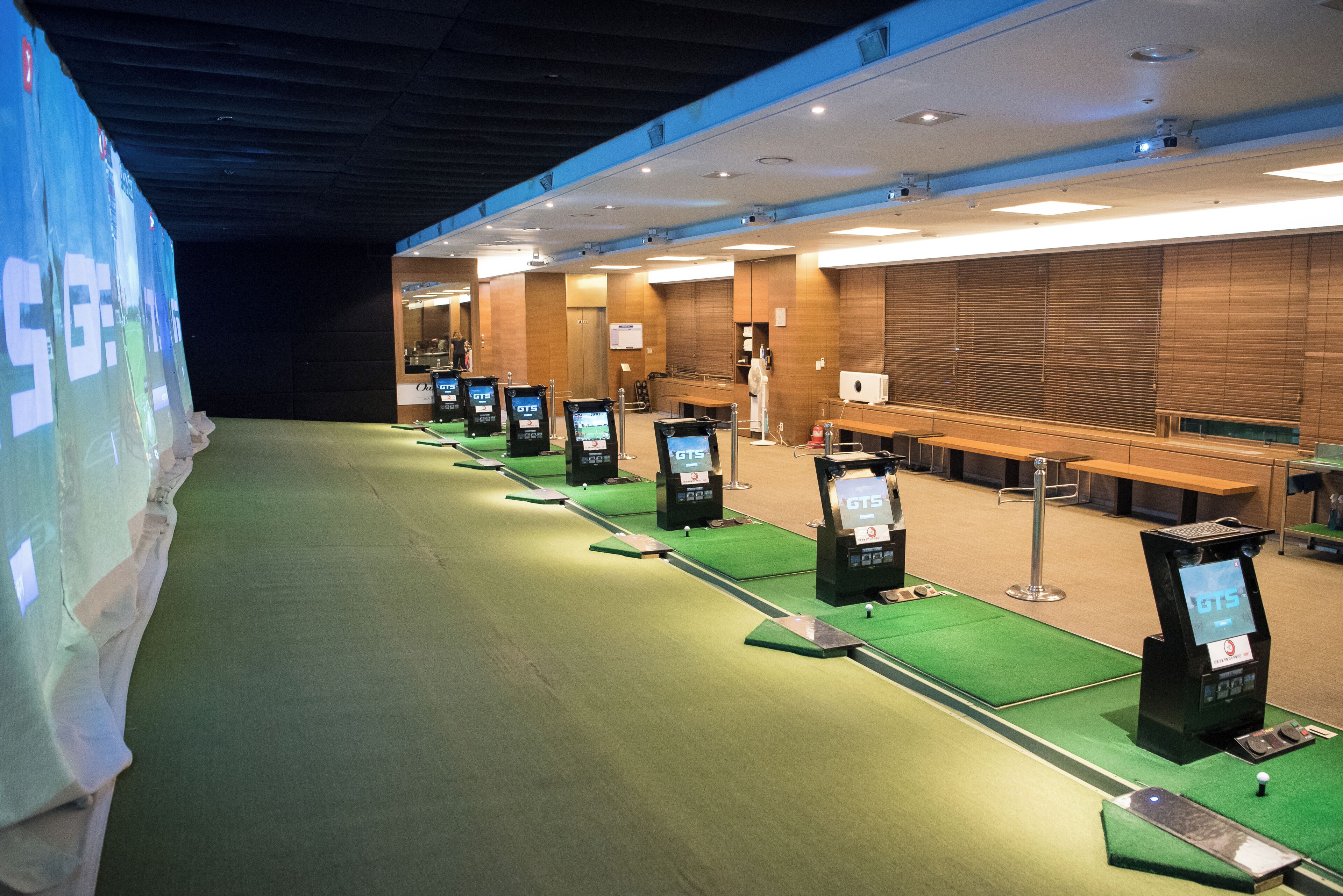 A hotel lobby with multiple self-service kiosks, a reception desk, and a seating area.
