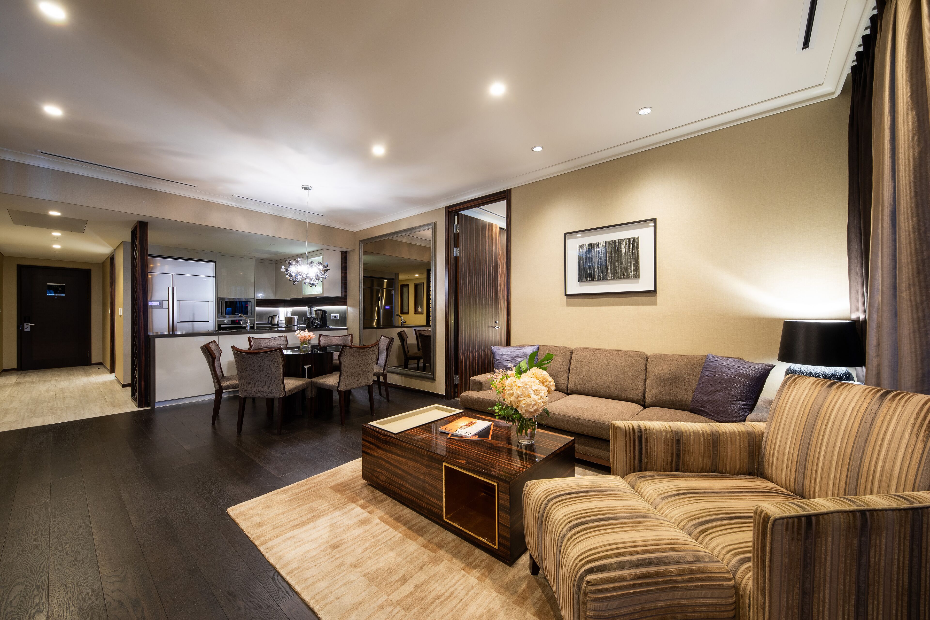 A modern living room with a sofa, coffee table, and dining area.