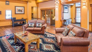 A spacious living area with leather sofas, a coffee table, and a patterned rug. - Hilton Vacation Club Villas de Santa Fe (Santa Fe)