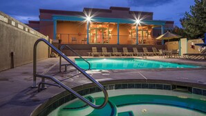 A swimming pool area with lounge chairs and a building with a balcony in the background. - Hilton Vacation Club Villas de Santa Fe (Santa Fe)