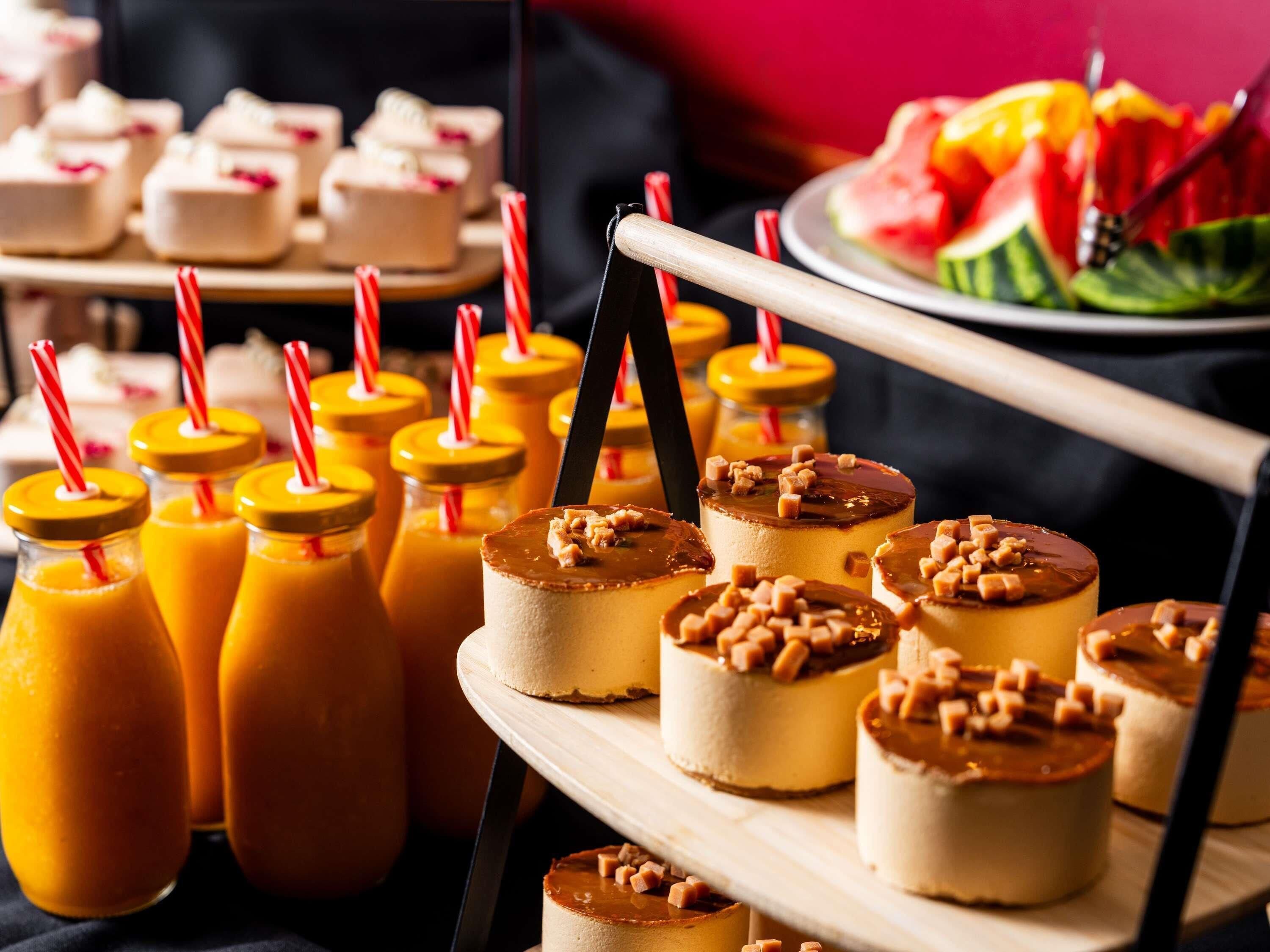A dessert table with various treats and beverages.