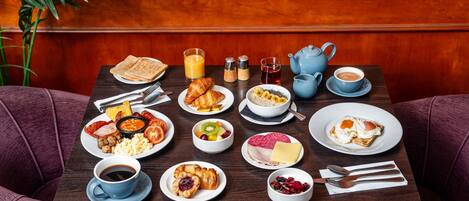 A breakfast table with various dishes, including toast, eggs, and fruit.